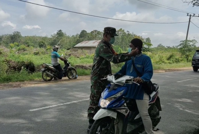 Kepada Pengendara, Babinsa Koramil 14/Kepenuhan Bagikan Masker Dan Himbau Disiplin Protokol Kesehata