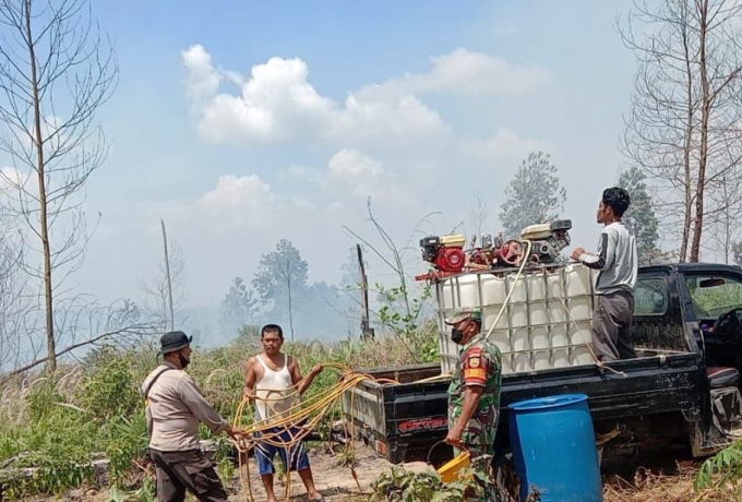 Babinsa Koramil 04/Pkl Kuras Lakukan Pendinginan Bekas Kebakaran Hutan