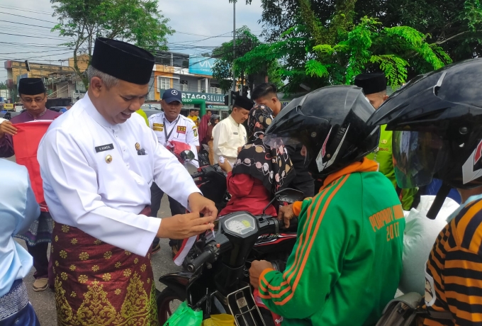 Dandim 0313/KPR Dampingi Pj. Bupati Kampar bagikan Bendera Merah Putih Kepada masyarkat