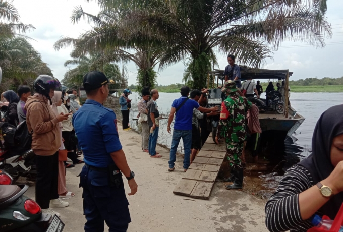Berikan Rasa Aman, Babinsa Bantu Warga Menyebrang Menggunakan Perahu